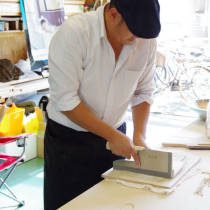 講師が蕎麦を切る方法を実演する