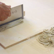 参加者が蕎麦包丁をつかって切る