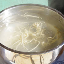 参加者が鍋で蕎麦を茹でる