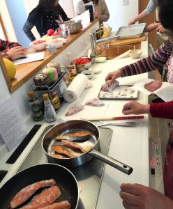 ＩＨキッチンを使って鮭のムニエルを料理する様子