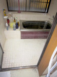 リフォーム前の洗い場と浴槽の様子。床はタイル張り、浴槽はステンレスの浴槽で古を感じさせる。