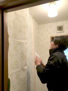 トイレの壁紙（クロス）を張り替えている様子