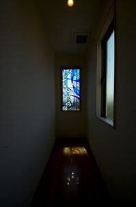 廊下の奥の窓にもステンドグラス風のガラスを入れている